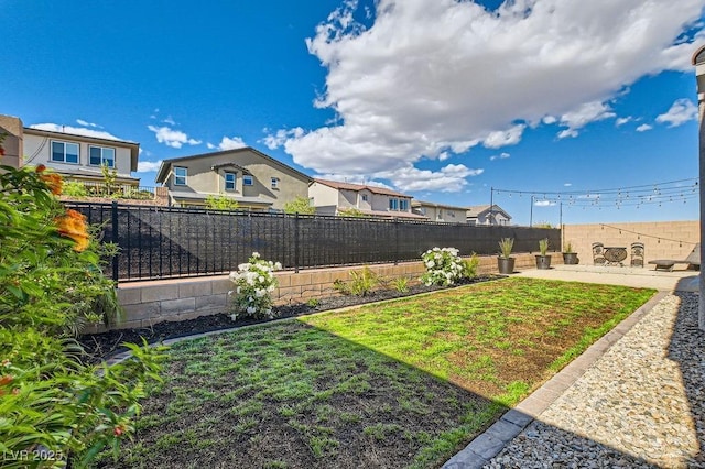 view of yard featuring a fenced backyard, a patio area, and a residential view