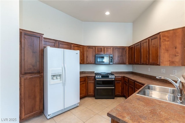 kitchen featuring white fridge with ice dispenser, stainless steel microwave, a sink, light tile patterned floors, and double oven range