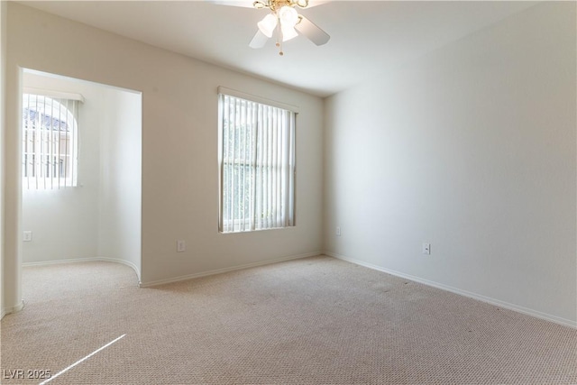 spare room with carpet floors, ceiling fan, and baseboards