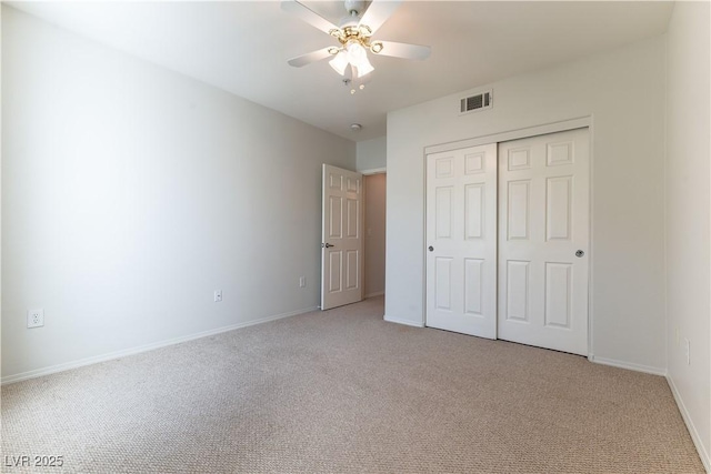 unfurnished bedroom with ceiling fan, visible vents, baseboards, a closet, and light carpet