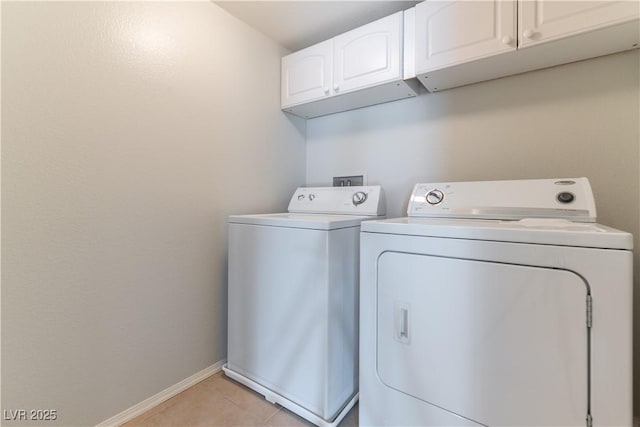 clothes washing area featuring cabinet space, baseboards, light tile patterned floors, and washing machine and clothes dryer