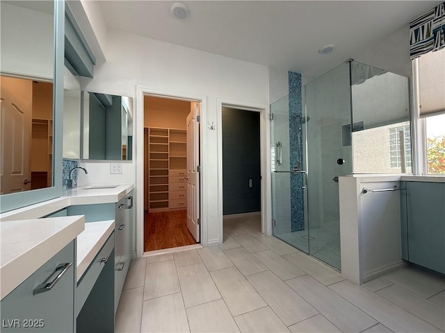 bathroom with vanity, a shower stall, tile patterned floors, and a walk in closet