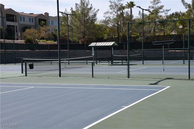 view of tennis court featuring fence and community basketball court