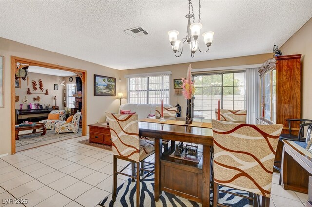 611 Spyglass Ln, Las Vegas, NV 89107 - dining area with visible vents, a textured ceiling, light tile patterned flooring, and a chandelier
