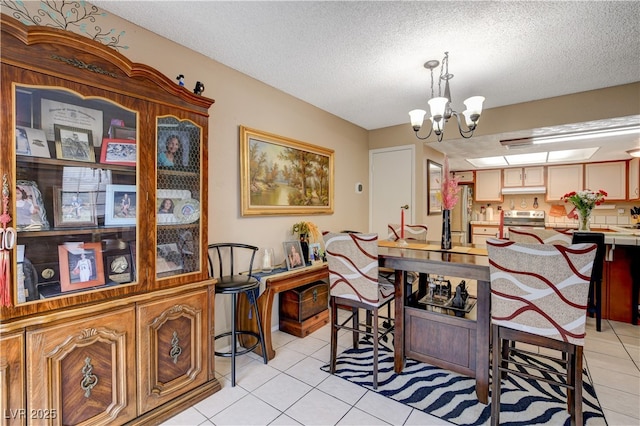611 Spyglass Ln, Las Vegas, NV 89107 - dining room featuring a textured ceiling, light tile patterned floors, and a notable chandelier