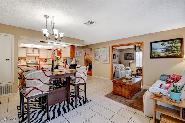 611 Spyglass Ln, Las Vegas, NV 89107 - dining room featuring visible vents, stairs, a textured ceiling, light tile patterned floors, and a notable chandelier