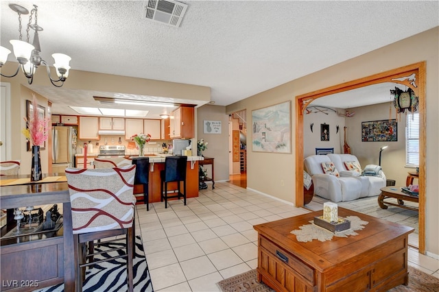 611 Spyglass Ln, Las Vegas, NV 89107 - living area with visible vents, a textured ceiling, light tile patterned floors, and a notable chandelier