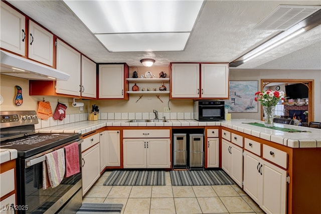 611 Spyglass Ln, Las Vegas, NV 89107 - kitchen with a sink, a peninsula, under cabinet range hood, electric stove, and light tile patterned floors