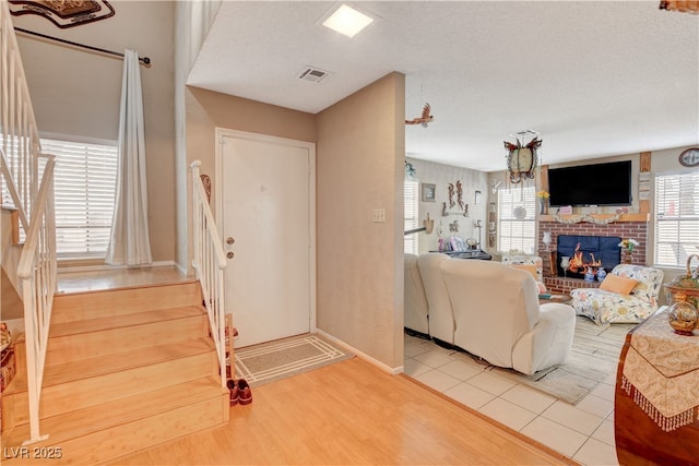 611 Spyglass Ln, Las Vegas, NV 89107 - entryway with visible vents, a brick fireplace, light wood-type flooring, stairway, and baseboards