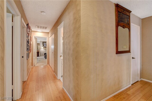 611 Spyglass Ln, Las Vegas, NV 89107 - corridor with visible vents, a textured ceiling, light wood-style flooring, and baseboards