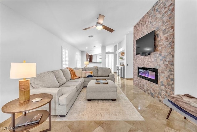 living area with a ceiling fan, visible vents, and a fireplace