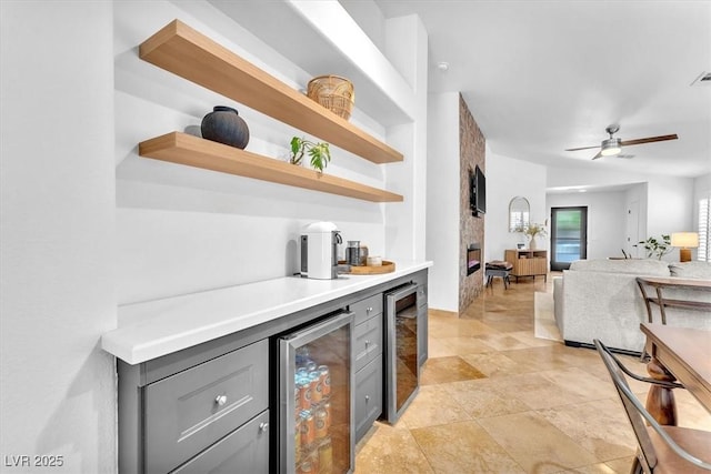 bar with wine cooler, a bar, a ceiling fan, and visible vents