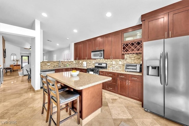 kitchen with decorative backsplash, a toaster, glass insert cabinets, a breakfast bar, and stainless steel appliances