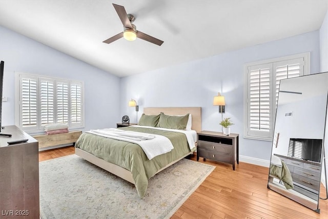 bedroom featuring baseboards, ceiling fan, vaulted ceiling, and light wood-type flooring