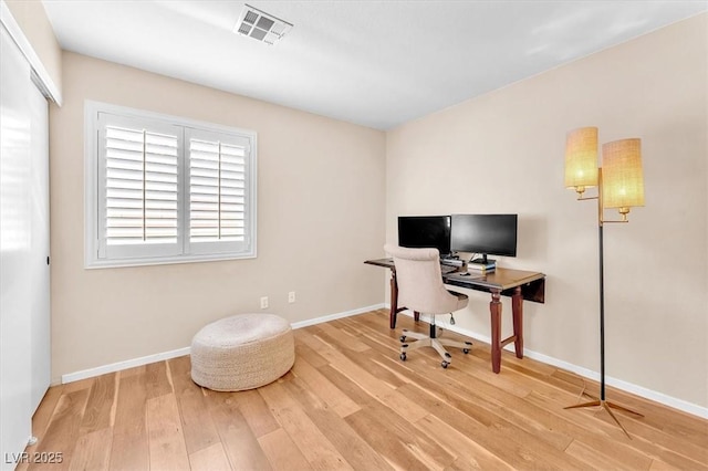 office featuring visible vents, baseboards, and wood finished floors