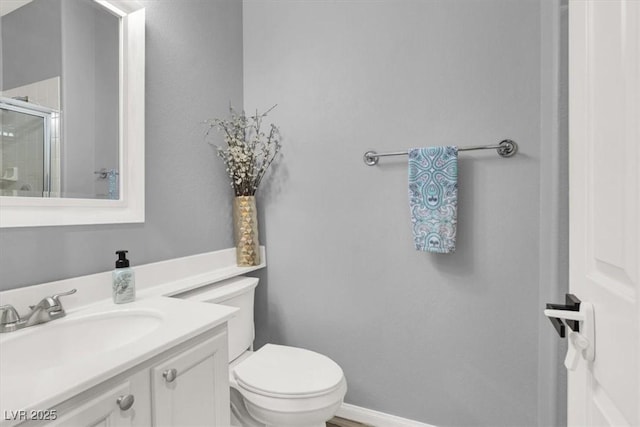 bathroom with vanity, a stall shower, and toilet