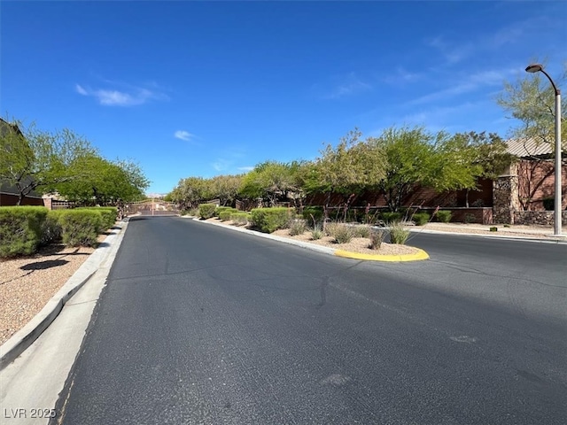 view of road featuring curbs and street lights