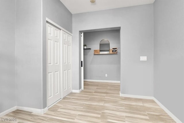 hall with baseboards and wood finished floors