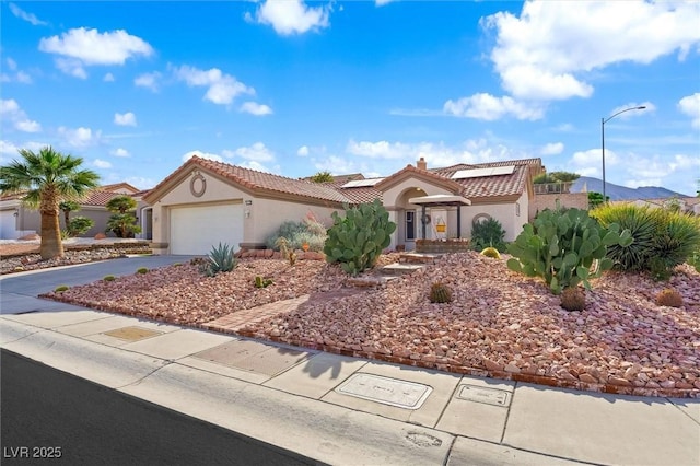 2725 Byron Dr, Las Vegas, NV 89134 - mediterranean / spanish house featuring roof mounted solar panels, stucco siding, a tile roof, driveway, and an attached garage