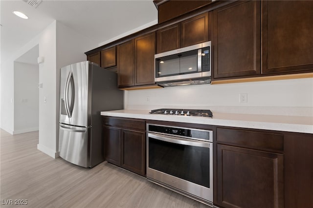 595 Beverly Pine Pl, Henderson, NV 89011 - kitchen featuring light countertops, dark brown cabinetry, stainless steel appliances, and light wood-type flooring