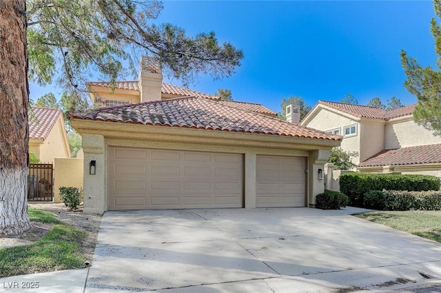 mediterranean / spanish home featuring an attached garage, stucco siding, driveway, and a tiled roof