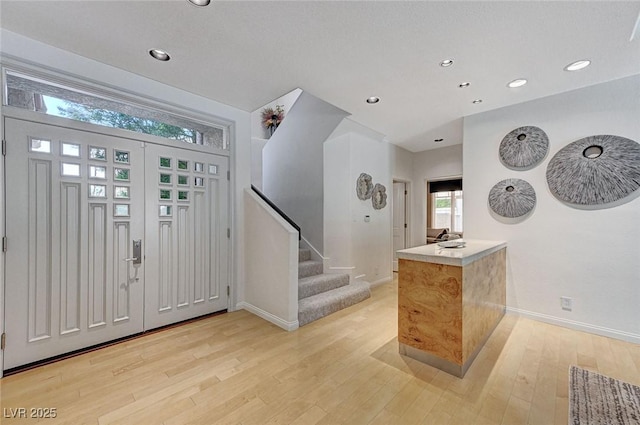 entrance foyer with baseboards, recessed lighting, light wood finished floors, and stairway