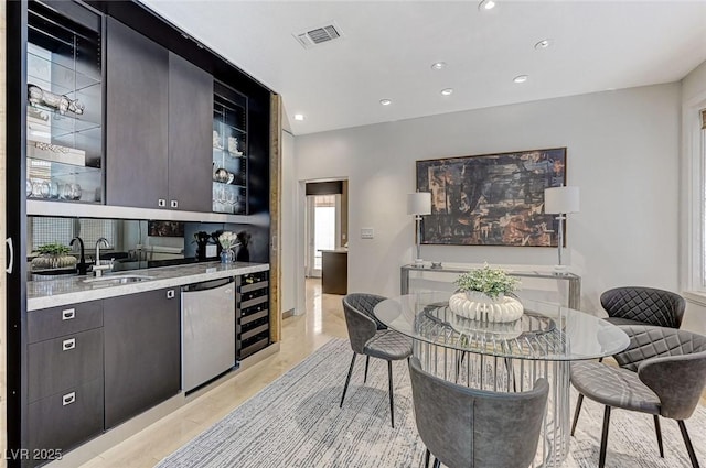 kitchen featuring visible vents, stainless steel dishwasher, a sink, glass insert cabinets, and recessed lighting