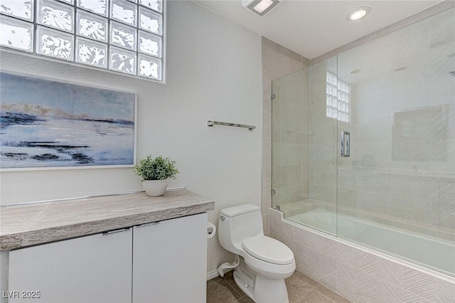 bathroom featuring tiled shower / bath combo, tile patterned floors, toilet, and a wealth of natural light