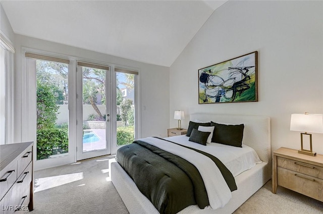 bedroom featuring multiple windows, vaulted ceiling, light carpet, and access to exterior