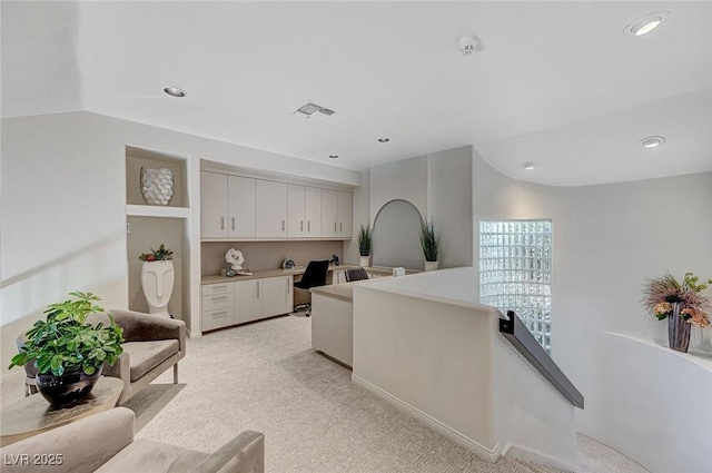 interior space with visible vents, light countertops, white cabinets, light carpet, and recessed lighting