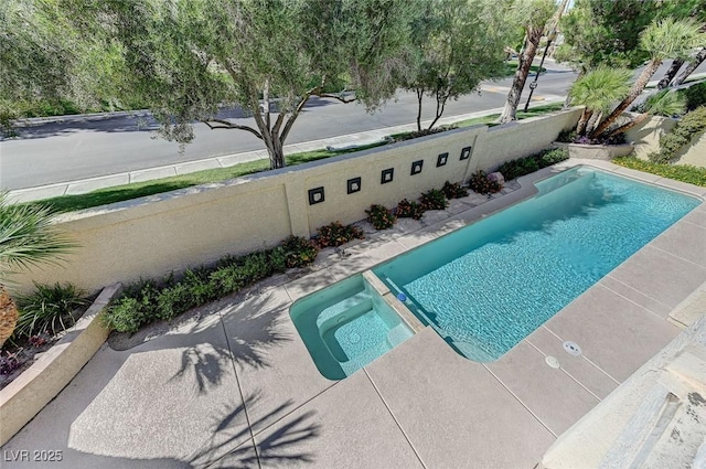 view of pool with a pool with connected hot tub