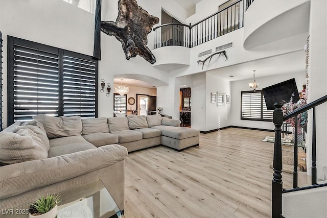 3738 Falcon Springs Dr, Las Vegas, NV 89147 - living room with an inviting chandelier, arched walkways, wood finished floors, and visible vents