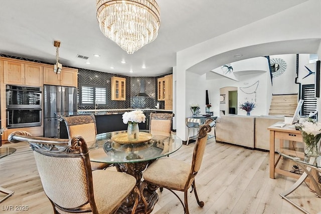 3738 Falcon Springs Dr, Las Vegas, NV 89147 - dining area with an inviting chandelier, arched walkways, light wood-type flooring, and visible vents