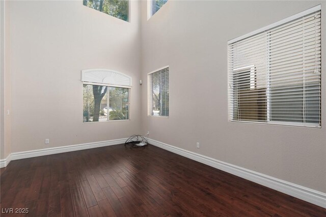 7736 Villa Andrade Ave, Las Vegas, NV 89131 - unfurnished room with baseboards, wood finished floors, and a high ceiling