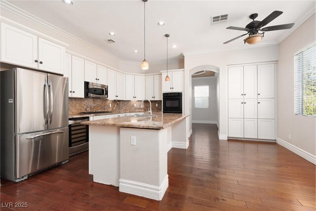7736 Villa Andrade Ave, Las Vegas, NV 89131 - kitchen with appliances with stainless steel finishes, arched walkways, a ceiling fan, a sink, and ornamental molding