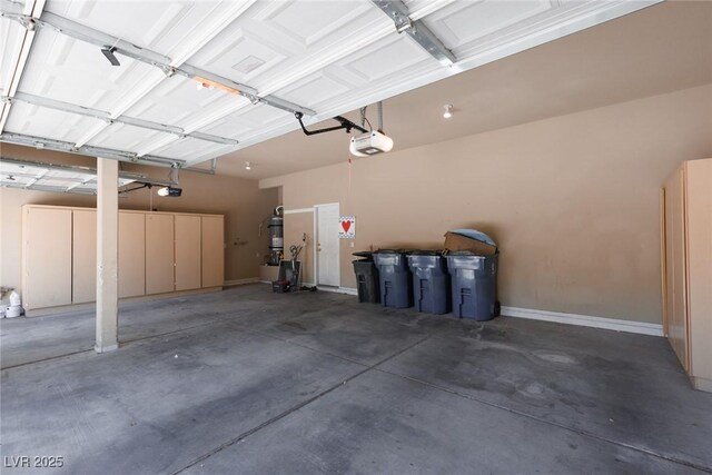 7736 Villa Andrade Ave, Las Vegas, NV 89131 - garage featuring a garage door opener, a central vacuum unit, and baseboards