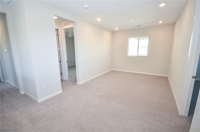 empty room with baseboards, visible vents, recessed lighting, and light colored carpet
