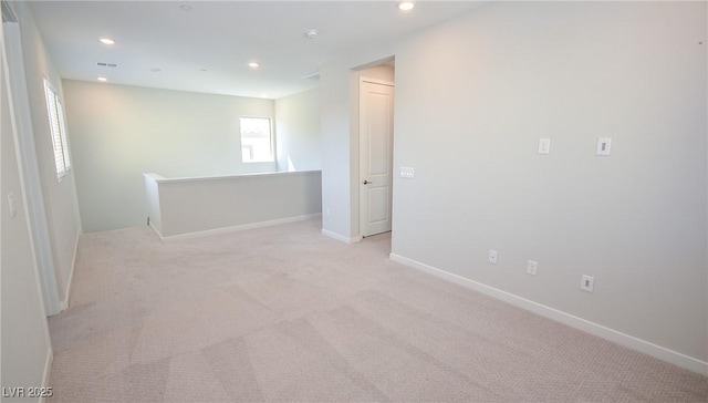 spare room featuring baseboards, recessed lighting, visible vents, and light carpet