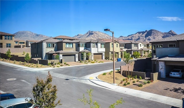 view of street with curbs, street lights, a mountain view, and a residential view