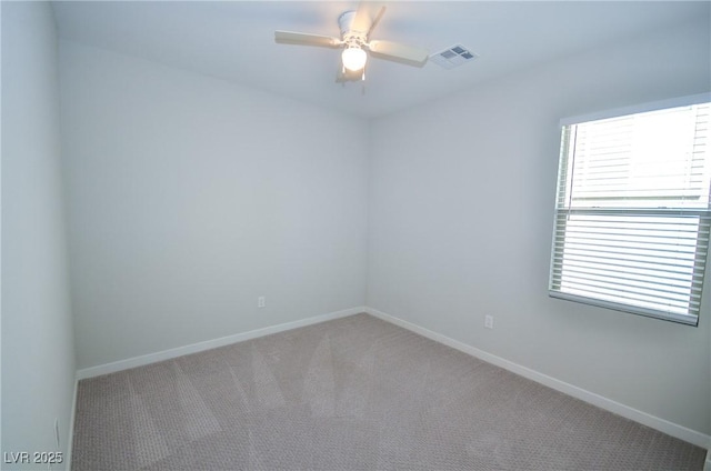 spare room with baseboards, light carpet, a ceiling fan, and visible vents