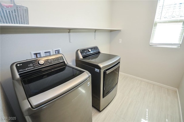 laundry room with baseboards, laundry area, and washer and clothes dryer