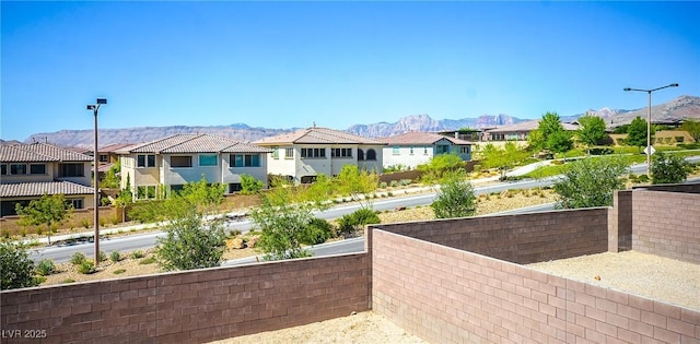 exterior space with fence, a residential view, and a mountain view