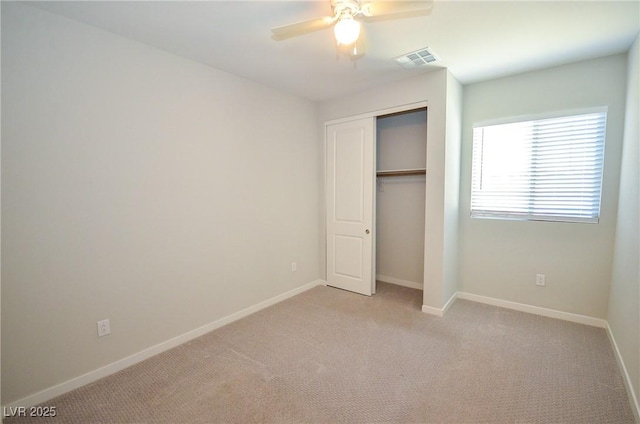 unfurnished bedroom with a closet, baseboards, light colored carpet, and visible vents