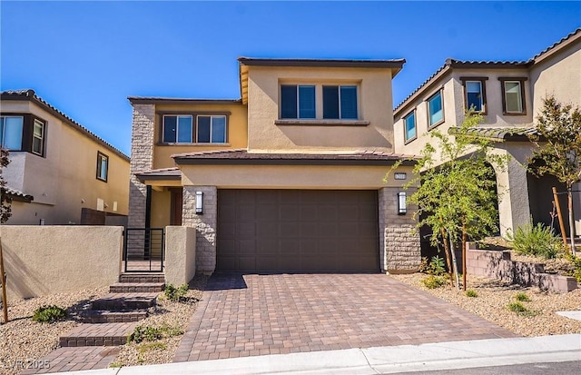 view of front facade with decorative driveway, a garage, stucco siding, and stone siding