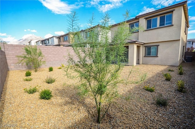 back of house featuring a fenced backyard and stucco siding