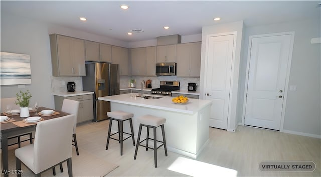 12101 Arrebol Ave, Las Vegas, NV 89138 - kitchen featuring appliances with stainless steel finishes, gray cabinetry, a kitchen breakfast bar, tasteful backsplash, and recessed lighting