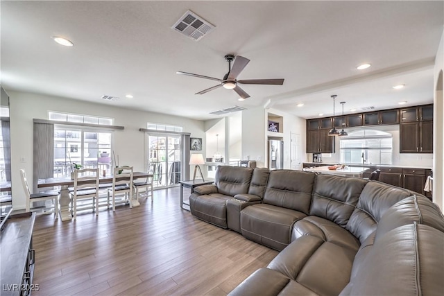 living area featuring a ceiling fan, dark wood-style floors, and visible vents