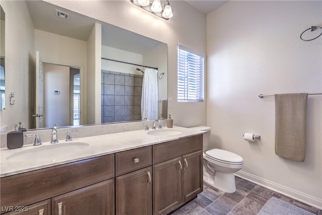 full bath featuring toilet, baseboards, visible vents, and a sink