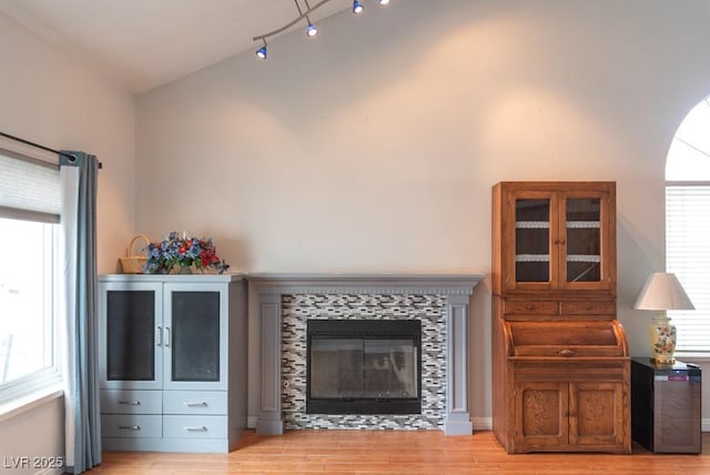 3008 Blue Fin Cir, Las Vegas, NV 89128 - living room with light wood-style flooring, a tile fireplace, and lofted ceiling
