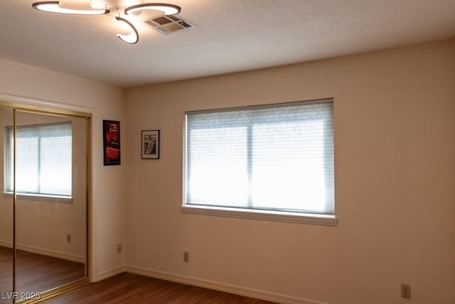 3008 Blue Fin Cir, Las Vegas, NV 89128 - unfurnished bedroom with a closet, wood finished floors, multiple windows, and baseboards